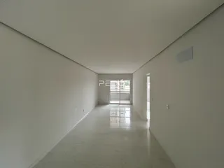 Corredor interno de uma residência com paredes brancas e piso claro.
