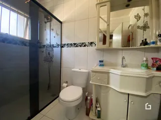 Um banheiro com revestimento cerâmico e louças sanitárias brancas.