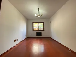 Ambiente interno com piso de madeira e paredes brancas.