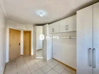 Hall de entrada com piso de cerâmica e armários brancos.