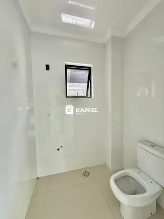 Foto de um banheiro interno com paredes brancas e piso claro.