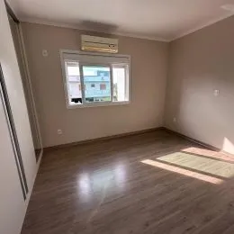 Ambiente interno com piso de madeira e janela na sala.