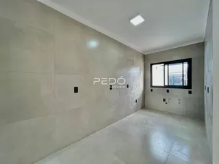 Interior de um corredor com paredes texturizadas e piso claro.