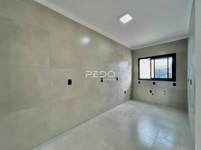 Interior de um corredor com paredes texturizadas e piso claro.