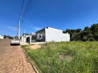 Fachada de uma casa moderna em Lajeado, Brasil, com gramado e vegetação ao redor.