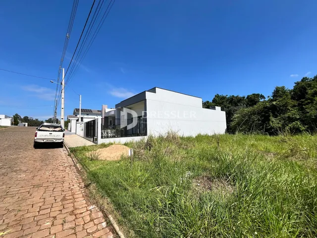Fachada de uma casa moderna em Lajeado, Brasil, com gramado e vegetação ao redor.
