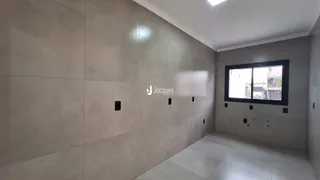 Parede interna com acabamento cinza claro e piso liso.