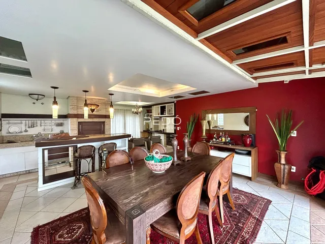 Uma sala de jantar com mesa de madeira e cozinha moderna.
