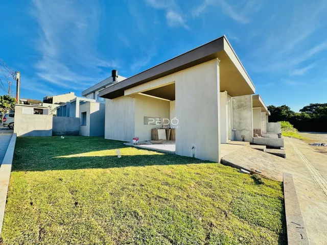 Fachada moderna de uma residência com jardim gramado.