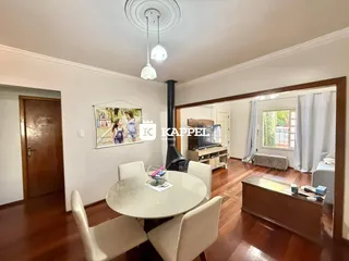 Foto de uma sala de jantar com mesa redonda e cadeiras brancas em um imóvel.