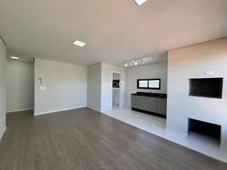 Sala de estar ampla com piso de madeira clara e paredes brancas.