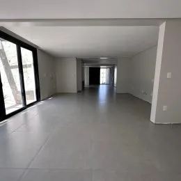 Hall de entrada longo com piso liso e paredes claras.