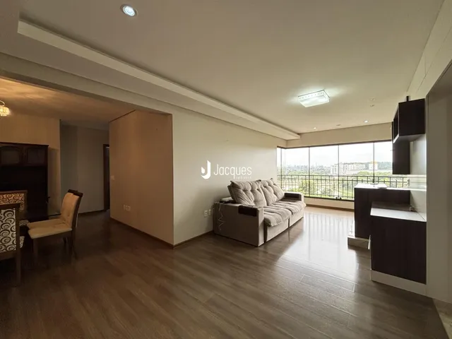 Sala de estar com piso de madeira e grande janela em um imóvel em Lajeado.