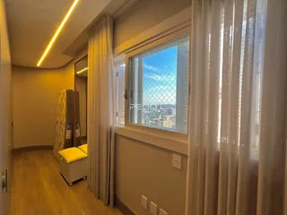 Hall de entrada com piso de madeira e janela com vista da cidade.