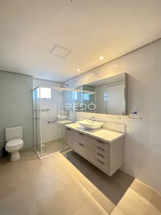 Foto de um banheiro moderno com box de vidro e bancada de mármore.