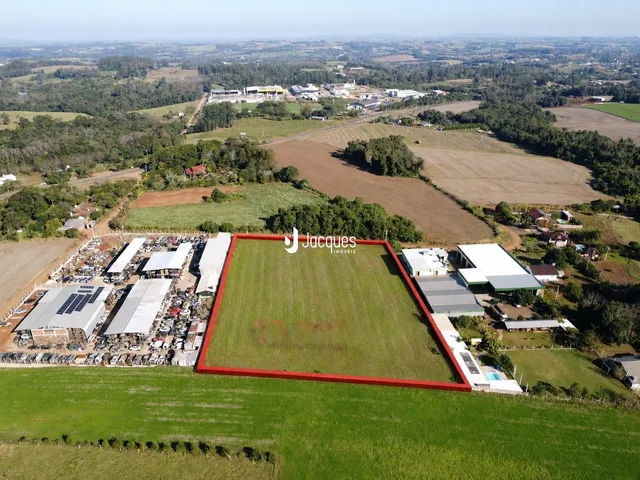 Vista aérea de um terreno rural com campos e estruturas.