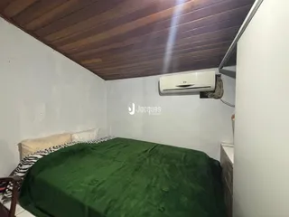 Quarto com cama e teto de madeira e ar-condicionado instalado.