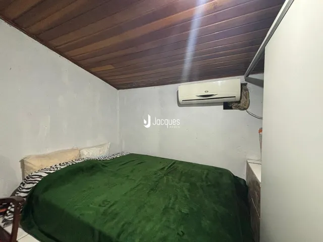 Quarto com cama e teto de madeira e ar-condicionado instalado.