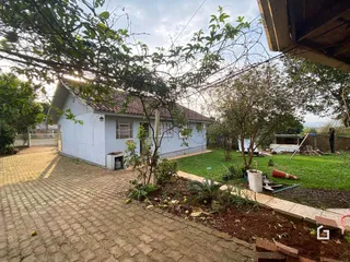 Vista externa de uma casa com jardim e entrada pavimentada em Lajeado, Brasil.
