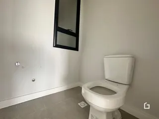 Foto de um banheiro interno com paredes brancas e um vaso sanitário branco.