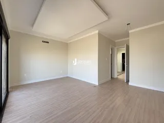 Foto de uma sala de estar ampla com piso de madeira clara.