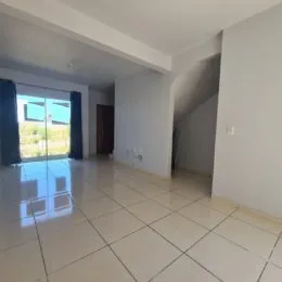 Sala de estar com piso de cerâmica clara e paredes brancas.