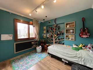 Quarto com paredes verde-água e decoração de madeira em Lajeado.