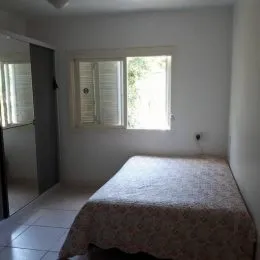 Quarto com cama e janela com persianas no interior da propriedade.
