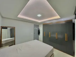 Quarto com armários embutidos e iluminação moderna.