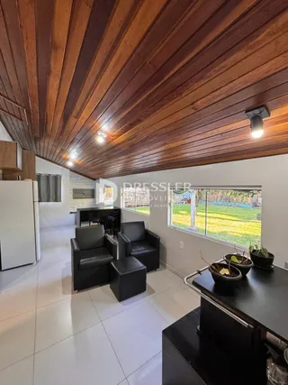 Sala de estar com teto de madeira e piso de cerâmica.