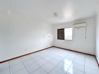 Ambiente interno de uma sala com piso de cerâmica e paredes brancas.