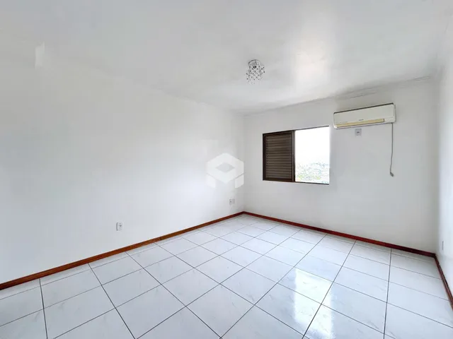 Ambiente interno de uma sala com piso de cerâmica e paredes brancas.
