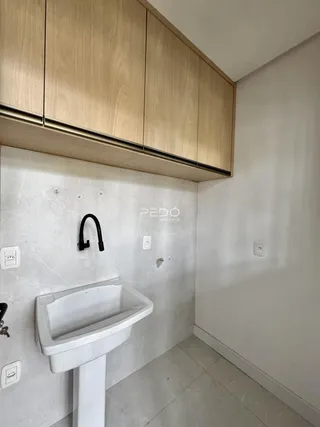 Foto interna de um banheiro com pia e revestimento branco.