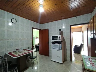 Hall de corredor interno com teto de madeira e paredes de azulejo.