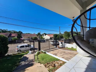 Vista da fachada da propriedade com cerca e jardim.