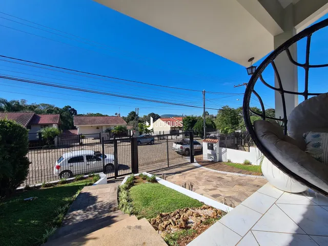 Vista da fachada da propriedade com cerca e jardim.