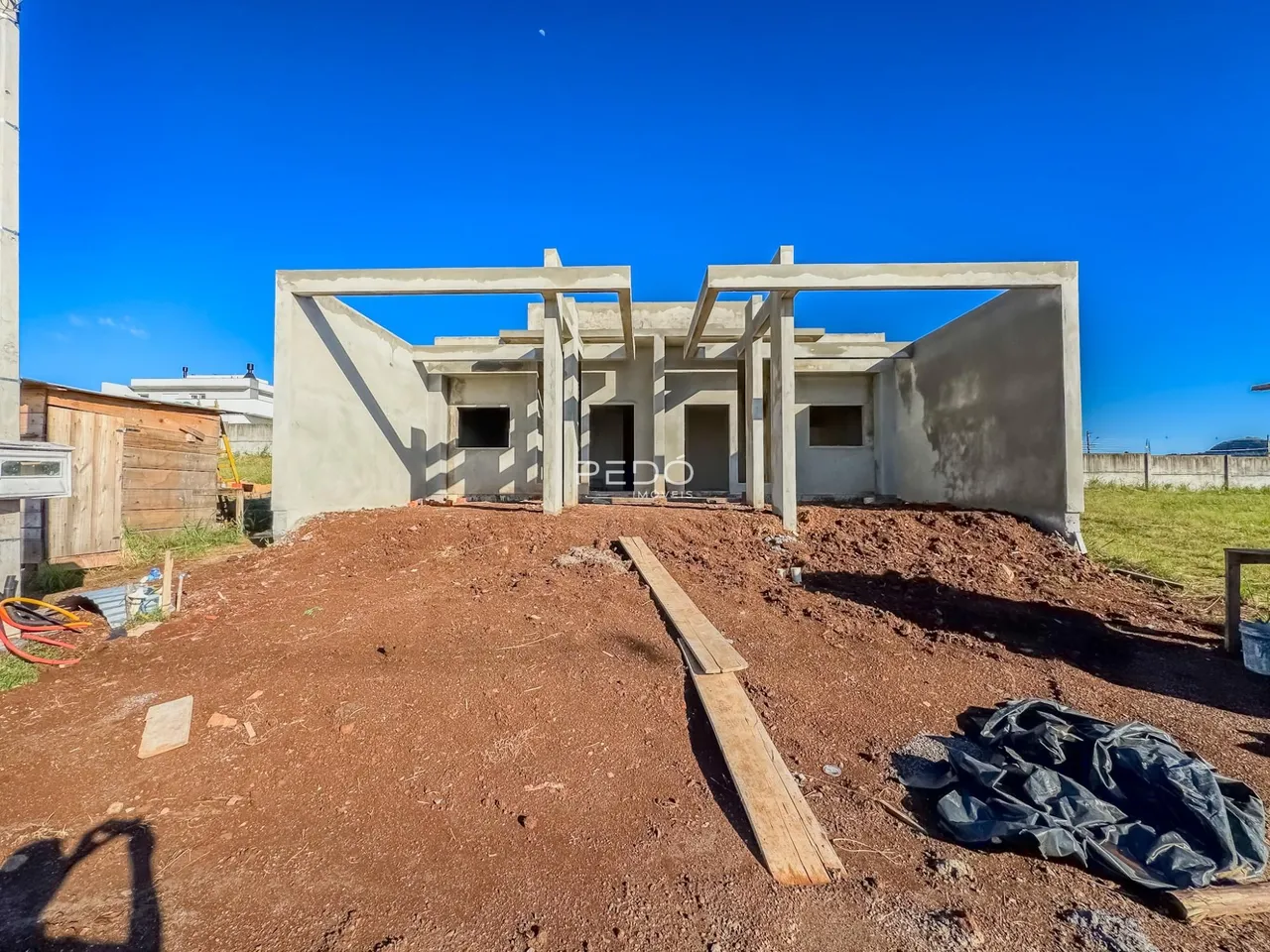 Fachada de uma construção em Lajeado, Brasil, em terreno com terra exposta.