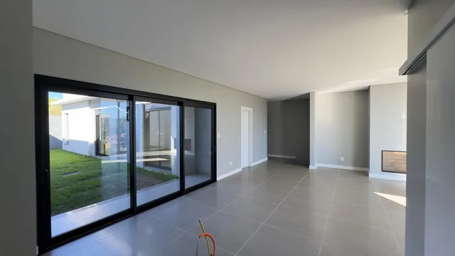 Sala de estar com portas de vidro que dão acesso a um quintal.