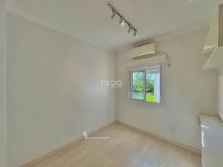 Sala de estar com piso de madeira clara e janela.