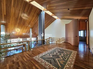 Interior de uma sala com teto e piso de madeira.