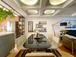 Sala de estar com mesa de jantar e decoração moderna em um apartamento.