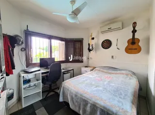 Quarto com cama e mesa de trabalho em um apartamento.