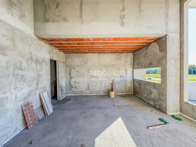 Imagem de um espaço interno com paredes de concreto aparente e teto de tijolos expostos.