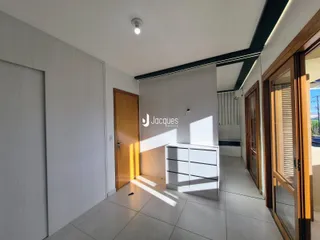Hall de entrada com portas de madeira e um armário branco.