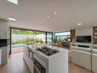 Cozinha moderna com vista para o pátio e piscina externa.