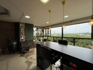 Sala de estar com vista para a natureza e grandes janelas.