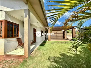 Foto da fachada da residência com jardim e garagem.