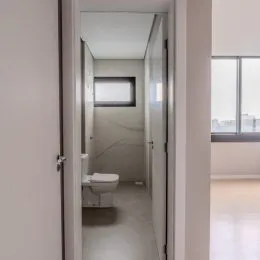 Corredor interno com paredes brancas e piso claro.