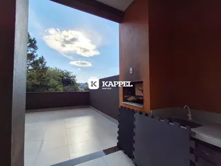 Vista externa com piso de cerâmica clara e vegetação ao fundo.