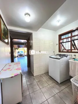 Uma cozinha com revestimento de azulejos brancos e piso de cerâmica.